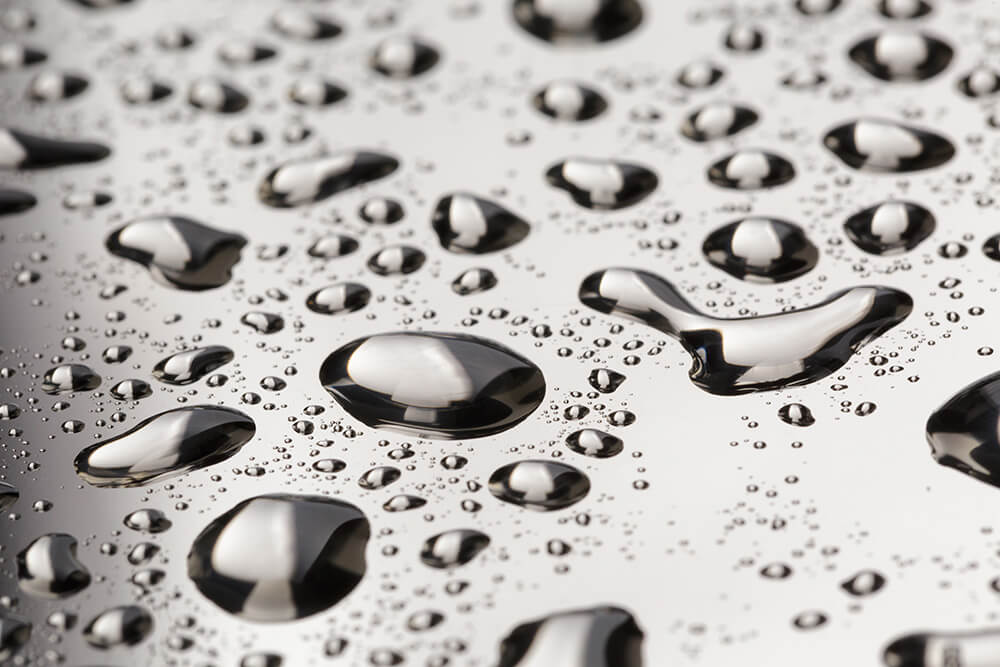 abstract water drops on polished stainless steel surface, close up